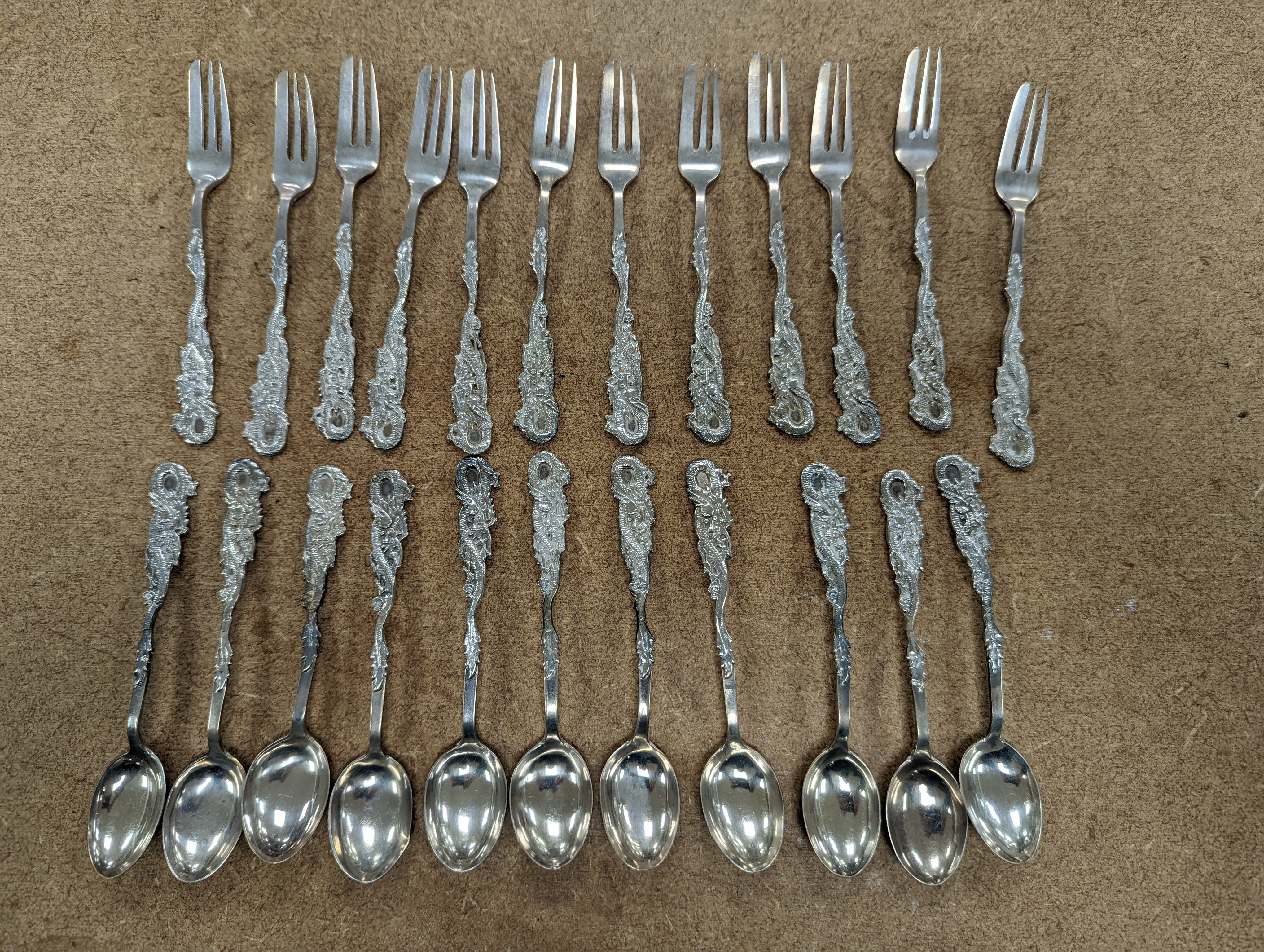 A set of twelve Chinese sterling tea forks, with dragon handles by YCCo and eleven similar teaspoons, 8oz.